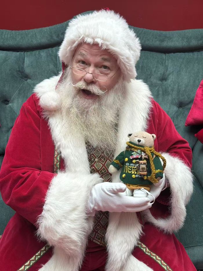 The real Fred Bear plush sitting with Santa